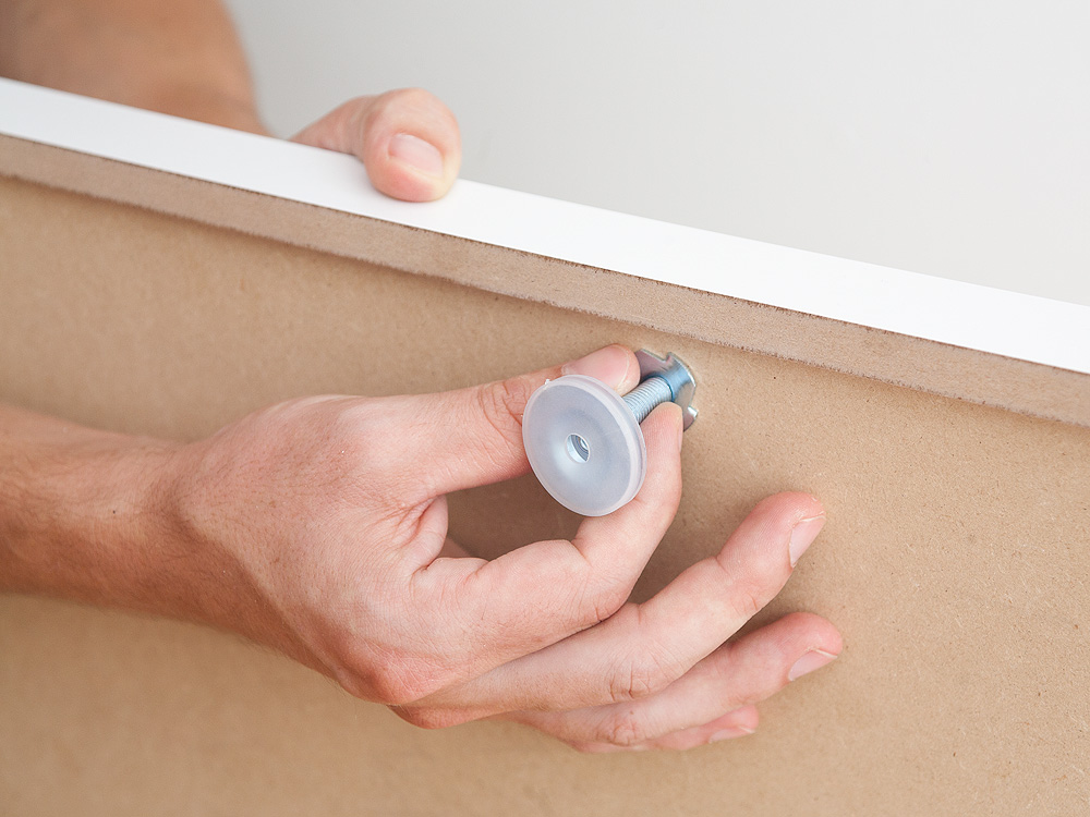 Einschraubene eines Stellfußes in den Sockel